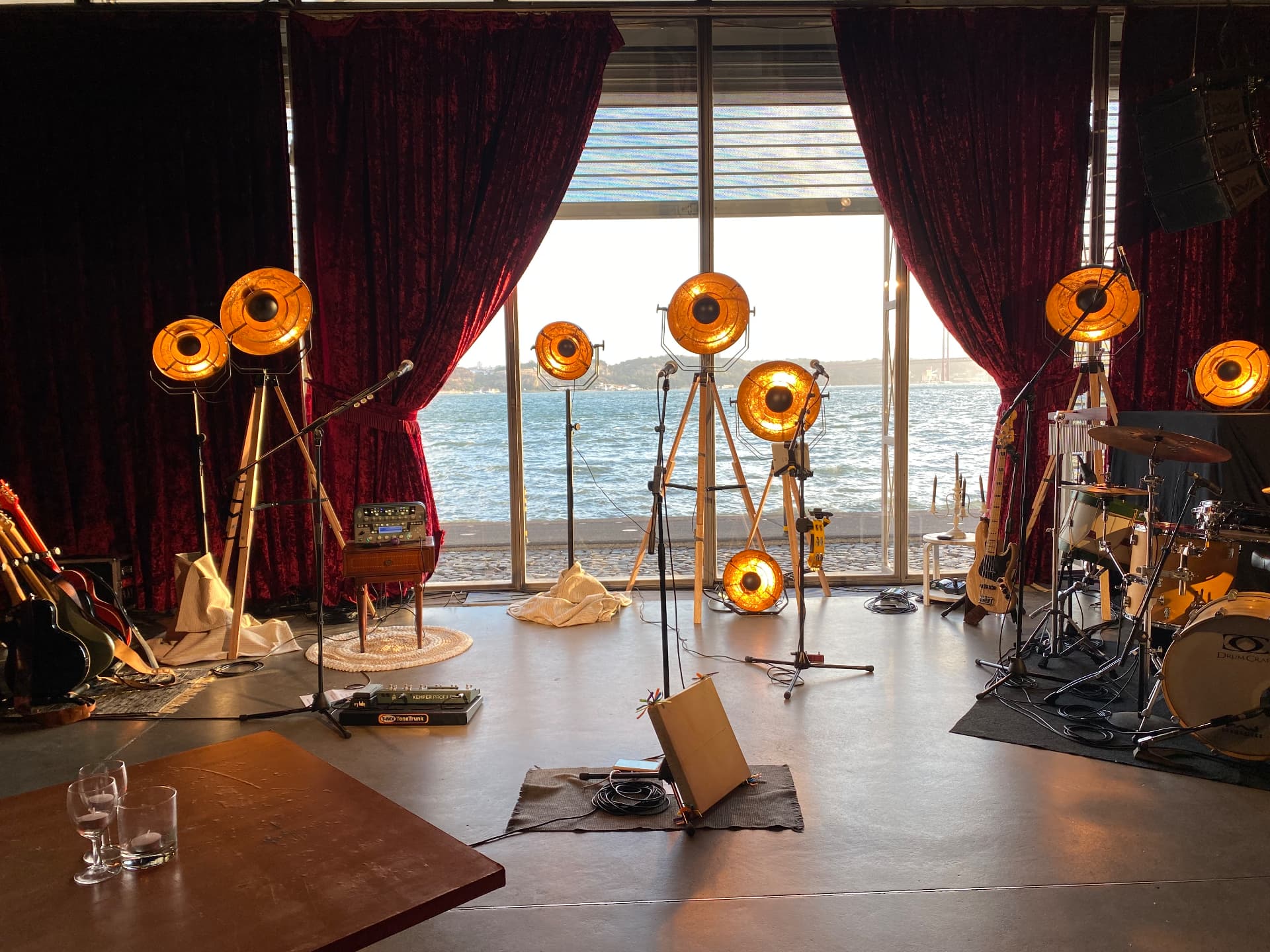 Palco com instrumentos, luzes e cortinas abertas para o Tejo